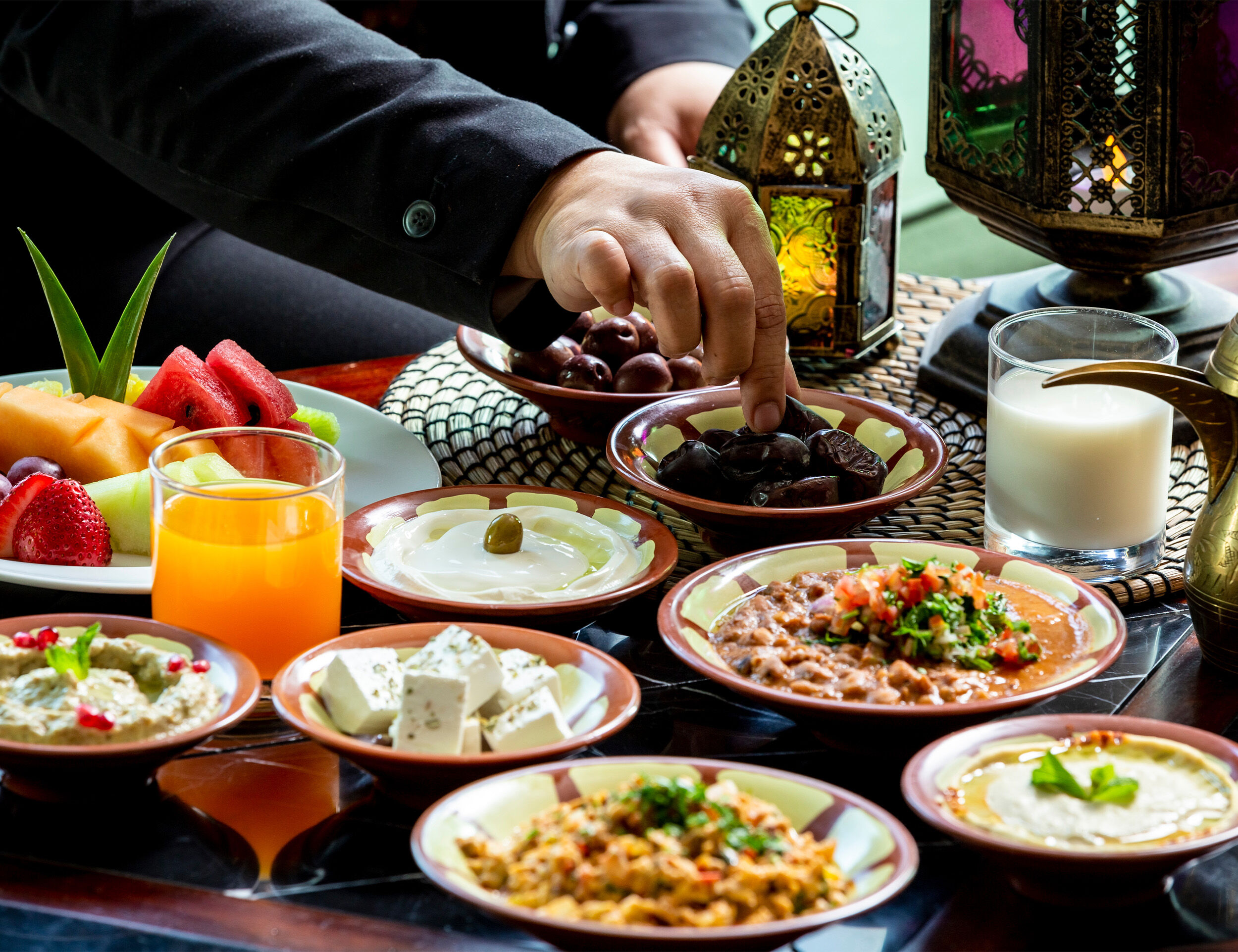 Traditional Eid feast with dates, fruits, yogurt, cheese, and Middle Eastern dishes served with lanterns and Arabic coffee